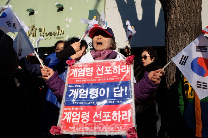 ▲ 27일 오후 헌법재판소 앞에서 박근혜 대통령 탄핵에 반대하는 한 시민이 계엄령을 선포하라는 손피켓을 들고 있다. 사진=이치열 기자 truth710@