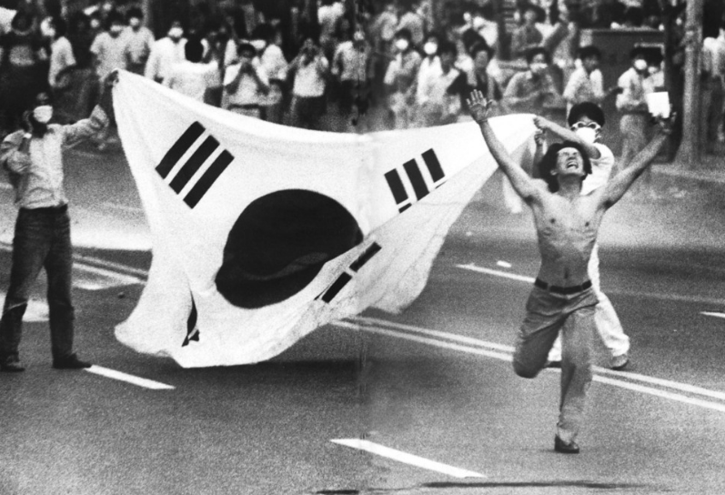 ▲ 1987년 6월항쟁을 상징하는 그림. 부산 문현로터리에서 경찰을 향해 저항하는 시민의 모습뒤로 태극기가 보인다.
