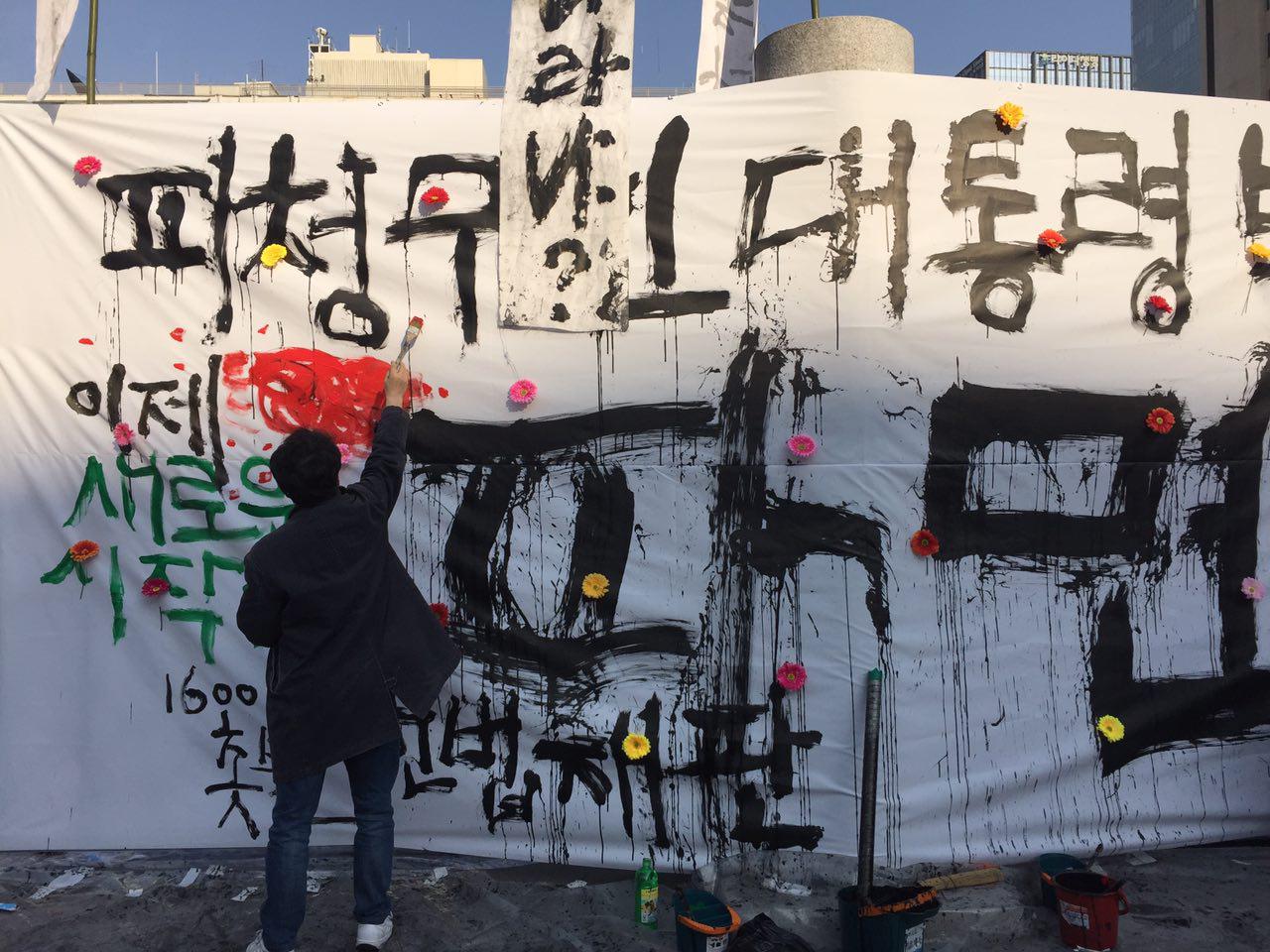 ▲ 예술가들이 박근혜 전 대통령의 파면을 축하하는 상징물을 그리고 있다. 사진=이하늬 기자