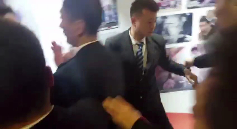 ▲ 한 중국 경호원이 이충우 기자를 발로 걷어찬 후 뒤로 나오고 있다.사진=CBS 제공 영상 캡쳐