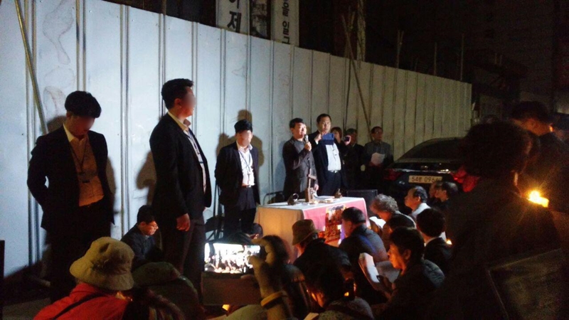 ▲ 강남향린교회 목사 및 교인들은 3월30일 저녁 7시 경비 용역들이 지키고 서 있는 강제집행 현장에서 예배를 올렸다. 사진=&#039;예수살기&#039; 제공