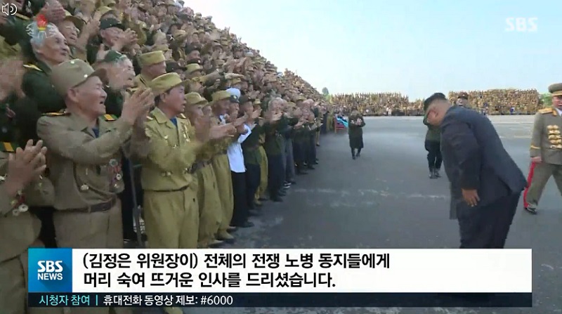 ▲ 전승절 65주년을 맞아 열린 노병대회의 참가한 인민군 참전 노병들과 기념찰영을 할 때 김정은 국무위원장이 고개를 숙여 인사하는 모습. 사진= SBS 보도 화면