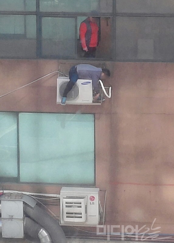 지난 2015년 3월23일 오후 서울 영등포구 당산동에 있는 한 상가 건물 3층 외벽에서 에어컨 설치기사가 안전장치 없이 실외기 거치대 위에서 작업하는 모습.  ⓒ미디어오늘 자료사진