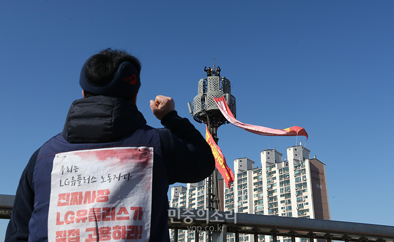▲ 14일 서울 강변북로 한강대교 인근 철탑에 올라 고공농성을 벌이는 노동자들을 지켜보는 동료 노동자. 사진=민중의소리.