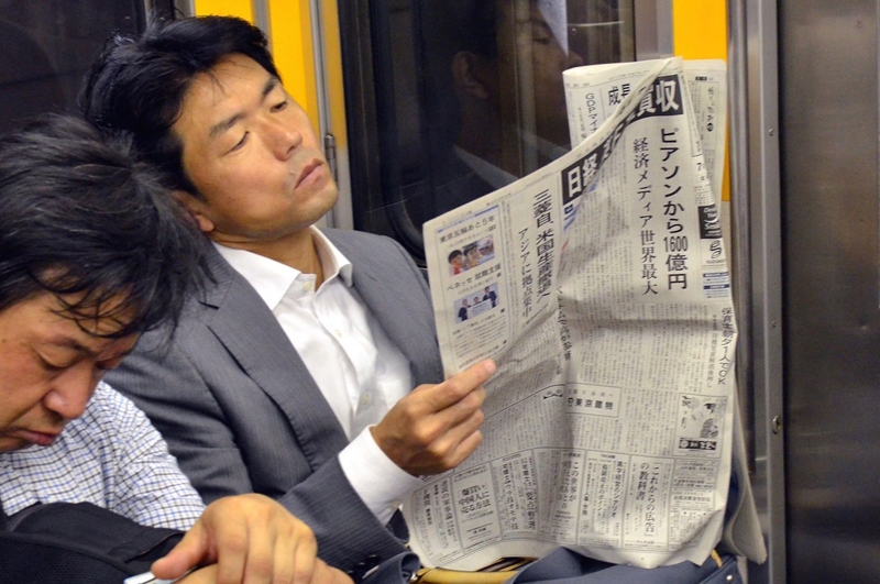 ▲ 한 남자가 일본 도쿄 전철 안에서 신문을 읽고 있다. 사진=Getty Images