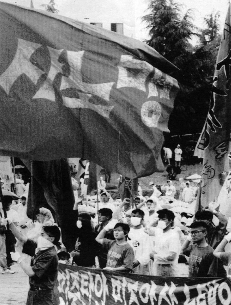 1991년 6월2일 부산대에서 열린 전국노동자학생 결의대회를 마치고 교문밖으로 나온 사노맹 대형깃발을 한 노동자가 흔들고 있는 모습. ⓒ연합뉴스