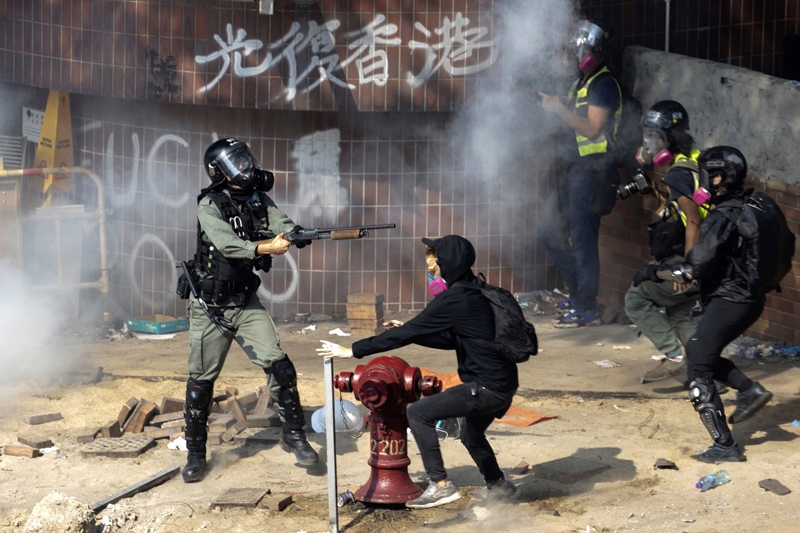 ▲ 지난 11월18일(현지시간) 홍콩 이공대 인근에서 경찰이 총을 겨누자 시위대와 취재진이 흩어지고 있다. ⓒ AP연합뉴스