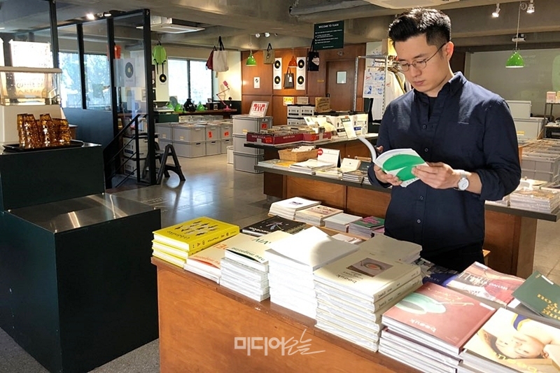 ▲조퇴계 편집장이 명동의 한 카페 겸 서점에서 책을 보고 있다. 사진= 정민경 기자.