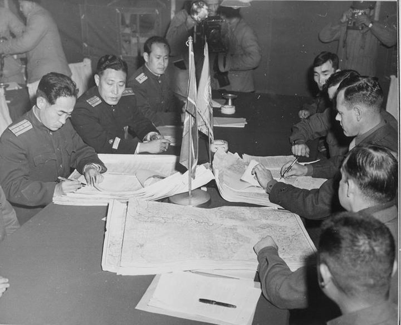▲ 1951년 10월 11일 판문점에서 열린 정전협정 실무자 회담에서 유엔군과 북한군 영관급 장교들이 지도를 놓고 협의하고 있다. 사진=위키미디어