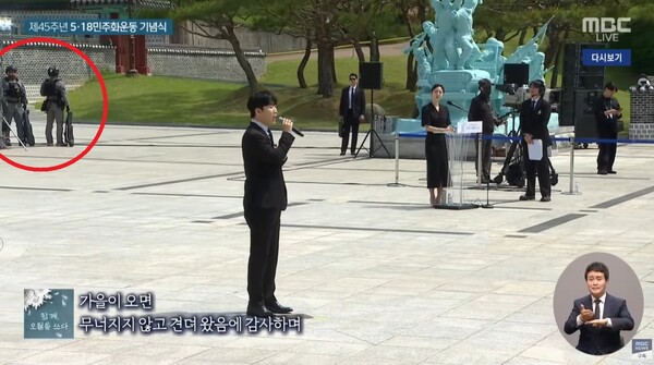 ▲18일 열린 5&middot;18민주화운동 기념식. 왼쪽 상단 붉은 색 원이 기념식장에 배치된 무장 군인. 사진=MBC 방송화면 갈무리