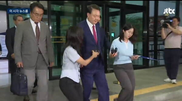 ▲윤석열 전 대통령이 5일 밤 내란특검의 2차 소환 조사를 마친 뒤 건물을 빠져나오면서 취재진의 질문을 받았으나 외면한채 지나치고 있다. 사진=JTBC 이시각 뉴스룸 영상 갈무리
