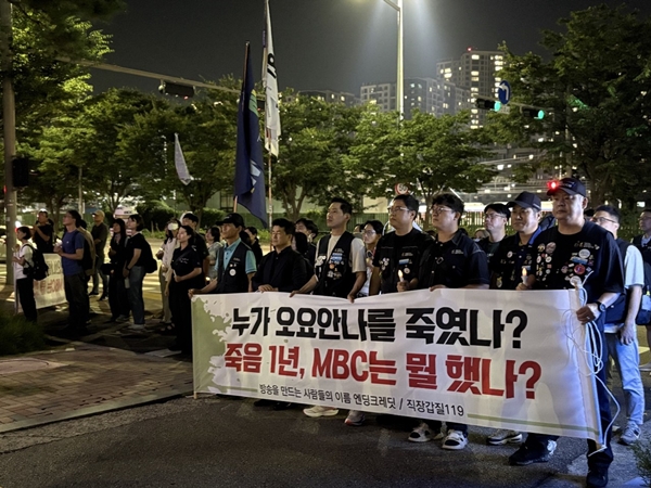 ▲ 추모제 말미에는 ‘누가 오요안나를 죽였나? 죽음 1년, MBC는 뭘 했나?’라고 적힌 현수막을 든 시민들이 약 30분 동안 MBC 사옥을 한 바퀴 행진했다. 시민들은 MBC 사옥 앞을 지키고 있는 MBC 직원들과 경찰들을 향해 구호를 외쳤다. 사진=윤유경 기자.