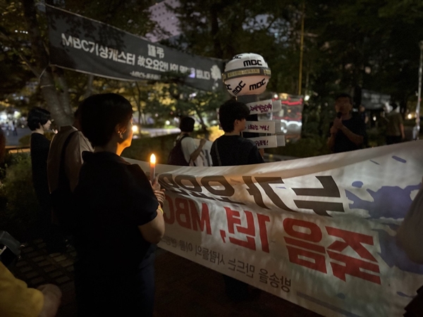 ▲ 추모제 말미에는 ‘누가 오요안나를 죽였나? 죽음 1년, MBC는 뭘 했나?’라고 적힌 현수막을 든 시민들이 약 30분 동안 MBC 사옥을 한 바퀴 행진했다. 사진=윤유경 기자.