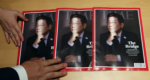 ▲ 지난 18일 서울 용산 대통령실에서 관계자가 이재명 대통령 취임 100일 기념 인터뷰가 실린 미국 타임지를 소개하고 있다. ⓒ연합뉴스