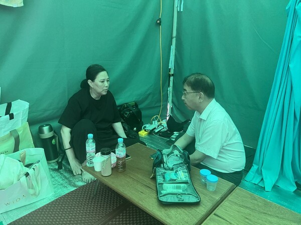 ▲임상혁 녹색병원 원장이 장씨의 단식 17일차를 맞은 24일 MBC 앞 단식농성장을 찾아 장씨를 면담하는 모습. 사진=엔딩크레딧